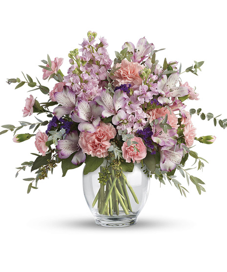 Pastel bouquet of alstroemeria, carnations and stock in a clear glass vase