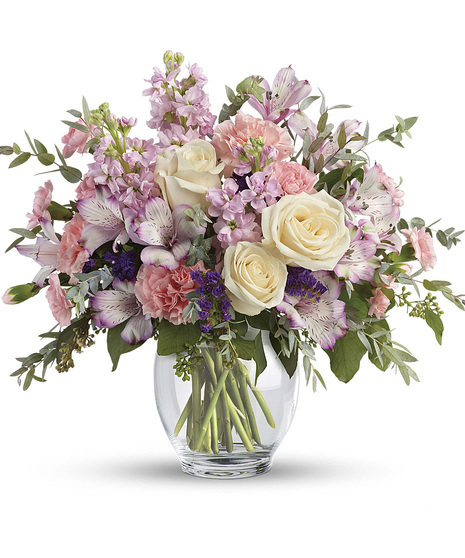 Pastel bouquet of alstroemeria, carnations and stock in a clear glass vase